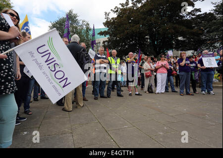 Swansea, UK. 10th July, 2014.  Pictured: A Unison flag with protesters at Castle Square Gardens, Swansea, south Wales.  Re: Strikes are taking place across the UK in a series of disputes with the government over pay, pensions and cuts, with more than a million public sector workers expected to join the action.  Firefighters, librarians and council staff are among those taking part from several trade unions, with rallies taking place across the UK. Credit:  D Legakis/Alamy Live News