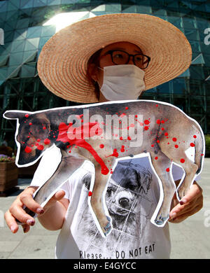 (140711) -- SEOUL, July 11, 2014 (Xinhua) -- An animal rights activist holds a placard during a protest against eating dog meat in front of the city hall of Seoul, South Korea, July 11, 2014. (Xinhua/Park Jin-hee)