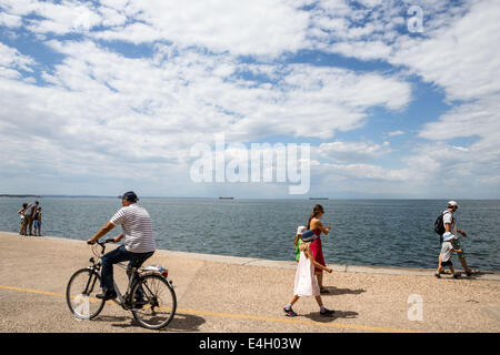 Thessaloniki, Greece. 11th July 2014. Tourists walk at the seafront of Thessaloniki, Greece. The Association of Greek Tourism Enterprises (SETE) increased its estimate for international tourist arrivals in 2014 to 19 million from 18.5 million last year. Thessaloniki, Greece on July 11, 2014. Credit:  Konstantinos Tsakalidis/Alamy Live News Stock Photo