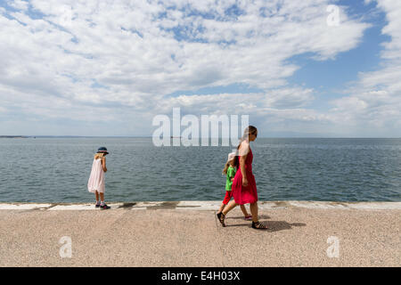 Thessaloniki, Greece. 11th July 2014. Tourists walk at the seafront of Thessaloniki, Greece. The Association of Greek Tourism Enterprises (SETE) increased its estimate for international tourist arrivals in 2014 to 19 million from 18.5 million last year. Thessaloniki, Greece on July 11, 2014. Credit:  Konstantinos Tsakalidis/Alamy Live News Stock Photo