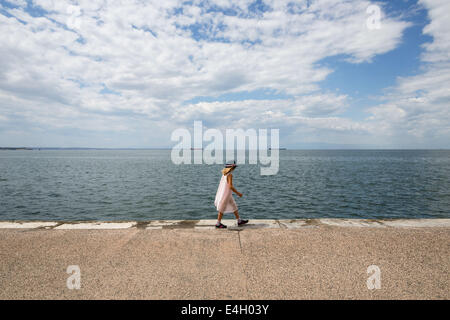Thessaloniki, Greece. 11th July 2014. Tourists walk at the seafront of Thessaloniki, Greece. The Association of Greek Tourism Enterprises (SETE) increased its estimate for international tourist arrivals in 2014 to 19 million from 18.5 million last year. Thessaloniki, Greece on July 11, 2014. Credit:  Konstantinos Tsakalidis/Alamy Live News Stock Photo