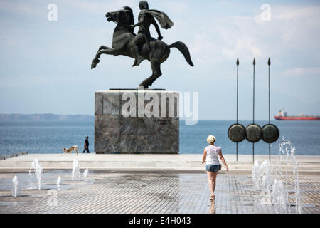 Thessaloniki, Greece. 11th July 2014. Tourist in front of a statue of Alexander the Great and his horse Bucephalus, during a sunny morning, in the city of Thessaloniki, Greece. The Association of Greek Tourism Enterprises (SETE) increased its estimate for international tourist arrivals in 2014 to 19 million from 18.5 million last year. Thessaloniki, Greece on July 11, 2014. Credit:  Konstantinos Tsakalidis/Alamy Live News Stock Photo