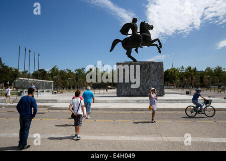 Thessaloniki, Greece. 11th July 2014. Tourists in front of a statue of Alexander the Great and his horse Bucephalus, during a sunny morning, in the city of Thessaloniki, Greece. The Association of Greek Tourism Enterprises (SETE) increased its estimate for international tourist arrivals in 2014 to 19 million from 18.5 million last year. Thessaloniki, Greece on July 11, 2014. Credit:  Konstantinos Tsakalidis/Alamy Live News Stock Photo