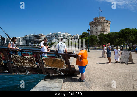 Thessaloniki, Greece. 11th July 2014. Tourists disembark from a cafe-bar boat in front of city's landmark, the White Tower, at the seaside of Thessaloniki, Greece. The Association of Greek Tourism Enterprises (SETE) increased its estimate for international tourist arrivals in 2014 to 19 million from 18.5 million last year. Thessaloniki, Greece on July 11, 2014. Credit:  Konstantinos Tsakalidis/Alamy Live News Stock Photo