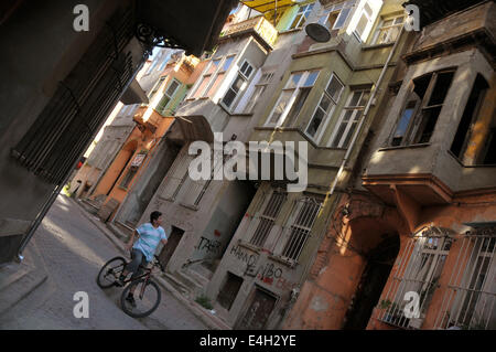 A young Turkish boy on a bicycle calls a friend on an old street in the Fener/Balat area by the Golden Horn. Stock Photo