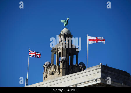 Liverbird on top of the Royal Liver Building at Pier Head, Liverpool with british flags blowing in the wind. Stock Photo