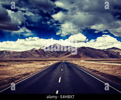 Vintage retro effect filtered hipster style travel image of Travel forward concept background - road on plains in Himalayas Stock Photo