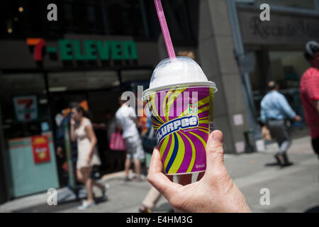 A Slurpee lover displays her free drink outside a 7-Eleven store in New York Stock Photo