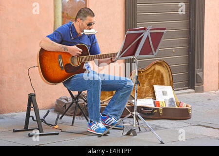 Street musician busker sitting beside a small display of his recorded music Ravenna Emilia Romagna Italy Stock Photo