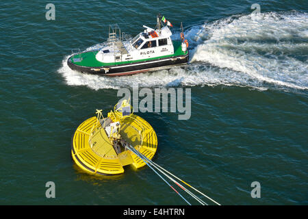 Aerial view  of Pilot motorboat & cruise ship ocean liner hawsers fixed to Floatex floating anchor buoy anchored to sea bed solar panel Ravenna Italy Stock Photo