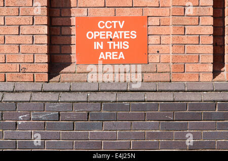 Sign on a brick wall saying 'CCTV operates in this area' Stock Photo