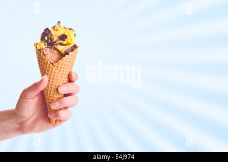 Woman hand holding chocolate ice cream in a cone. Stock Photo