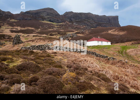Traditional crofters cottage at the foot of An Sgurr on the Isle of Eigg, Inner Hebrides (Small Isles) Scotland Stock Photo