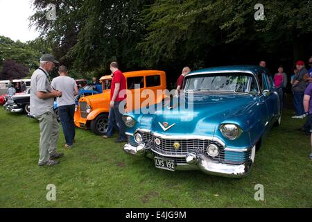 Manchester, UK  13th July 2014 A man admires a 1954 Cadillac Series 62 Sedan at the Didsbury and South Manchester Car Show in Didsbury Park, South Manchester.  Classic Car Show  Manchester, UK Credit:  John Fryer/Alamy Live News Stock Photo