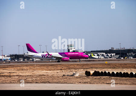 RIGA, LATVIA - APRIL 10, 2014: Wizz Air Airbus A320-232 after landing at Riga International Airport. Wizz Air is a Hungarian low Stock Photo