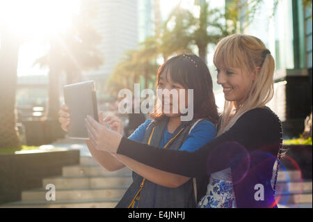 Two young women using digital tablet Stock Photo