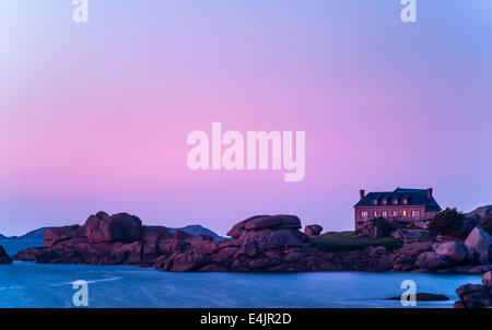 House on ocean coast in early morning. Cote de Granit Rose, Brittany, France Stock Photo