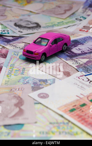 Pink toy car with pound notes Stock Photo