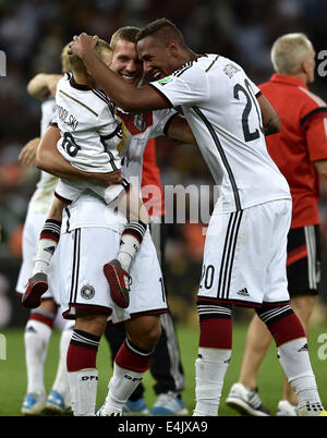 Rio De Janeiro, Brazil. 13th July, 2014. Germany's Lukas Podolski (L) carrying his son celebrates the victory with Jerome Boateng (R) after the final match between Germany and Argentina of 2014 FIFA World Cup at the Estadio do Maracana Stadium in Rio de Janeiro, Brazil, on July 13, 2014. Germany won 1-0 over Argentina after 120 minutes and took its fourth World Cup title on Sunday. Credit:  Qi Heng/Xinhua/Alamy Live News Stock Photo