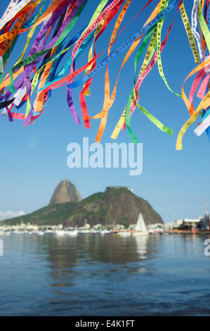 Brazilian wish ribbons flying above scenic view of Sugarloaf Mountain and Botafogo Bay Stock Photo