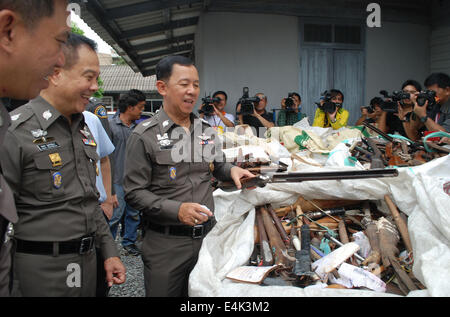 (140714) -- BANGKOK, July 14, 2014 (Xinhua) -- Acting National Police Chief Gen. Watcharapol Prasarnrajkit (3rd L) looks at old rifles on display in bags before being destroyed at a police weaponry office in Bangkok, Thailand, July 14, 2014. All together 34,350 guns that were seized by court orders between 2000-2013 will be destroyed in a ceremony on Tuesday. (Xinhua/Rachen Sageamsak) Stock Photo