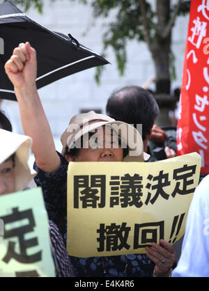 Tokyo, Japan. 14th July, 2014. People take part in a protest against Japan's conservative leader Shinzo Abe and his move on lifting ban on collective self-defense, near the Diet building in Tokyo, Japan, July 14, 2014. About four hundred Japanese demonstrators on Monday here took part in the protest, as the Japanese parliament kicked off a special session targeting the Abe's Cabinet's decision on collective self-defense. Credit:  Liu Tian/Xinhua/Alamy Live News Stock Photo