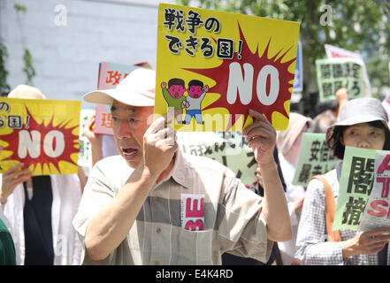 Tokyo, Japan. 14th July, 2014. People take part in a protest against Japan's conservative leader Shinzo Abe and his move on lifting ban on collective self-defense, near the Diet building in Tokyo, Japan, July 14, 2014. About four hundred Japanese demonstrators on Monday here took part in the protest, as the Japanese parliament kicked off a special session targeting the Abe's Cabinet's decision on collective self-defense. Credit:  Liu Tian/Xinhua/Alamy Live News Stock Photo