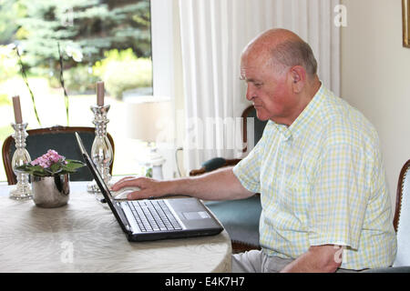 Senior man working on a laptop Stock Photo