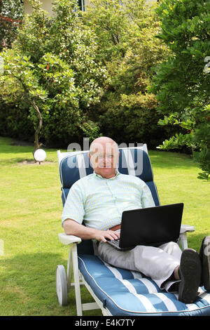 Senior man using laptop in garden Stock Photo
