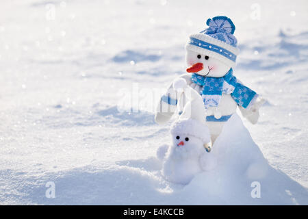 Two snowman on a snowy background. Stock Photo