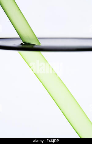 Drinking straw refracted by water Stock Photo