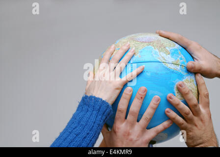 Teamwok concept with hands on globe Stock Photo