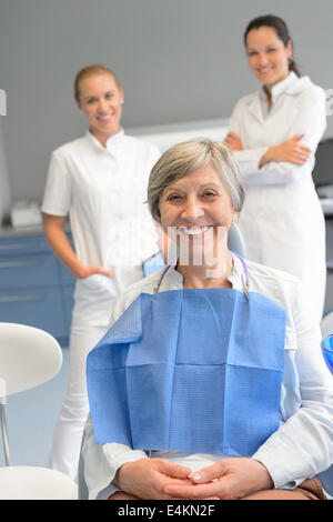 Senior woman patient with professional dentist team at dental surgery Stock Photo