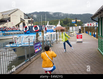 Bowness on Lake Windermere, UK. 14th July, 2014. Tourists making the most of a rainy day Japanese tourists have fun posing in the rain Credit:  Gordon Shoosmith/Alamy Live News Stock Photo