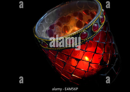 burning tea light in a red glass, close up, isolated on black background Stock Photo