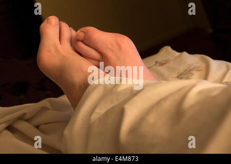 Man's feet in bed. Stock Photo