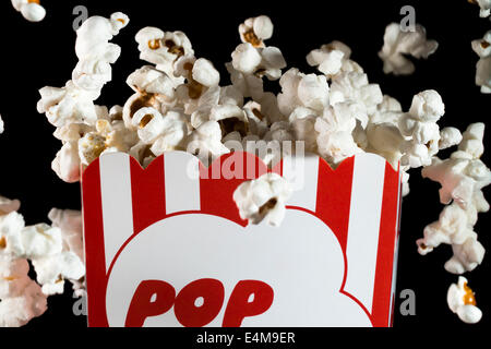 Popping Popcorn in box on black background Stock Photo