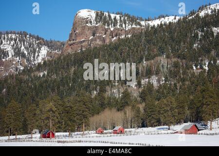 Beautiful winter scene of snow and red barns on a farm in the Rocky Mountains in Colorado. Stock Photo