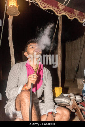 Visitor tries out hookah, a popular Middle Eastern smoking instrument for vaporizing and smoking flavored tobacco Stock Photo