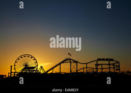 Ferris wheel and roller coaster at sunset, Pacific Park, Santa Monica Pier, Santa Monica, Los Angeles, California, USA Stock Photo