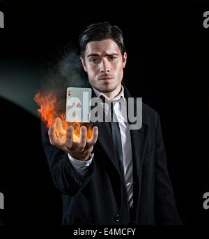 Magician produces an ace in flames Stock Photo