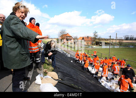 FILE - An archive picture dated 09 April 2006 shows German Chancellor Angela Merkel (L) visiting a dyke near Neu Garge, Germany. Merkel turns 60 on 17 July 2014. Photo: Patrick Lux/dpa Stock Photo