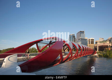 Cyclist crossing the Peace Bridge across the Bow River which connects pathways of north and south Calgary Stock Photo