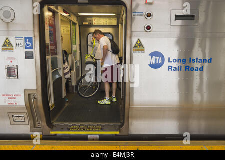 July 14, 2014 - Merrick, New York, U.S - During evening rush hour, passengers, including a man with a bicycle, are in a train car with door open at Merrick train station of Babylon branch, after MTA Metropolitan Transit Authority and Long Island Rail Road union talks deadlock, with potential LIRR strike looming just days ahead. (Credit Image: © Ann Parry/ZUMA Wire) Stock Photo