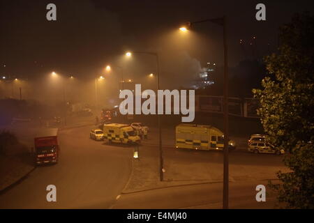 London, UK. 15th July, 2014. Some 70 FireFighters from across London called to tackle a fire in a waste transfer station on Scarab Close, Canning Town East London. Crews from as far away as Tooting were called to the scene to deal with the blaze which involved several hundred tonnes of waste materials. Thick smoke billowed from the blaze which resulted in LFB warning local residents to keep doors and windows closed. It is not yet known if the closure of close by Silvertown fire station exasperated the blaze as crews had to travel from further afield to the incident. Credit:  HOT SHOTS/Alamy Li Stock Photo