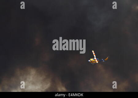 Aerial fire fighting a bush fire using water bomber helicopter in Banjup, Western Australia. Stock Photo