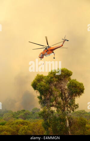 Aerial fire fighting a bush fire using water bomber helicopter in Banjup, Western Australia. Stock Photo