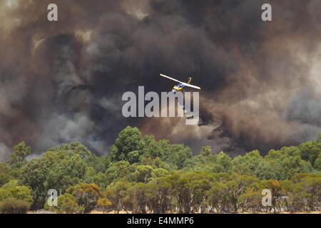 Aerial fire fighting a bush fire using water bomber helicopter in Banjup, Western Australia. Stock Photo