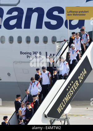 Berlin, Germany. 15th July, 2014. Germany's Philipp Lahm (bottom, C) steps out of the aircraft holding the World Cup trophy in his hands as Germany's national soccer squad arrives at Tegel airport in Berlin, Germany, 15 July 2014. Team Germany won the Brazil 2014 FIFA Soccer World Cup final against Argentina by 1-0, winning the World Champion title for the fourth time after the 1954, 1974 and 1990 World Cups. PHOTO: BERND VON JUTRCZENKA/dpa/Alamy Live News Stock Photo