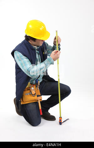 Laborer using measuring tape Stock Photo